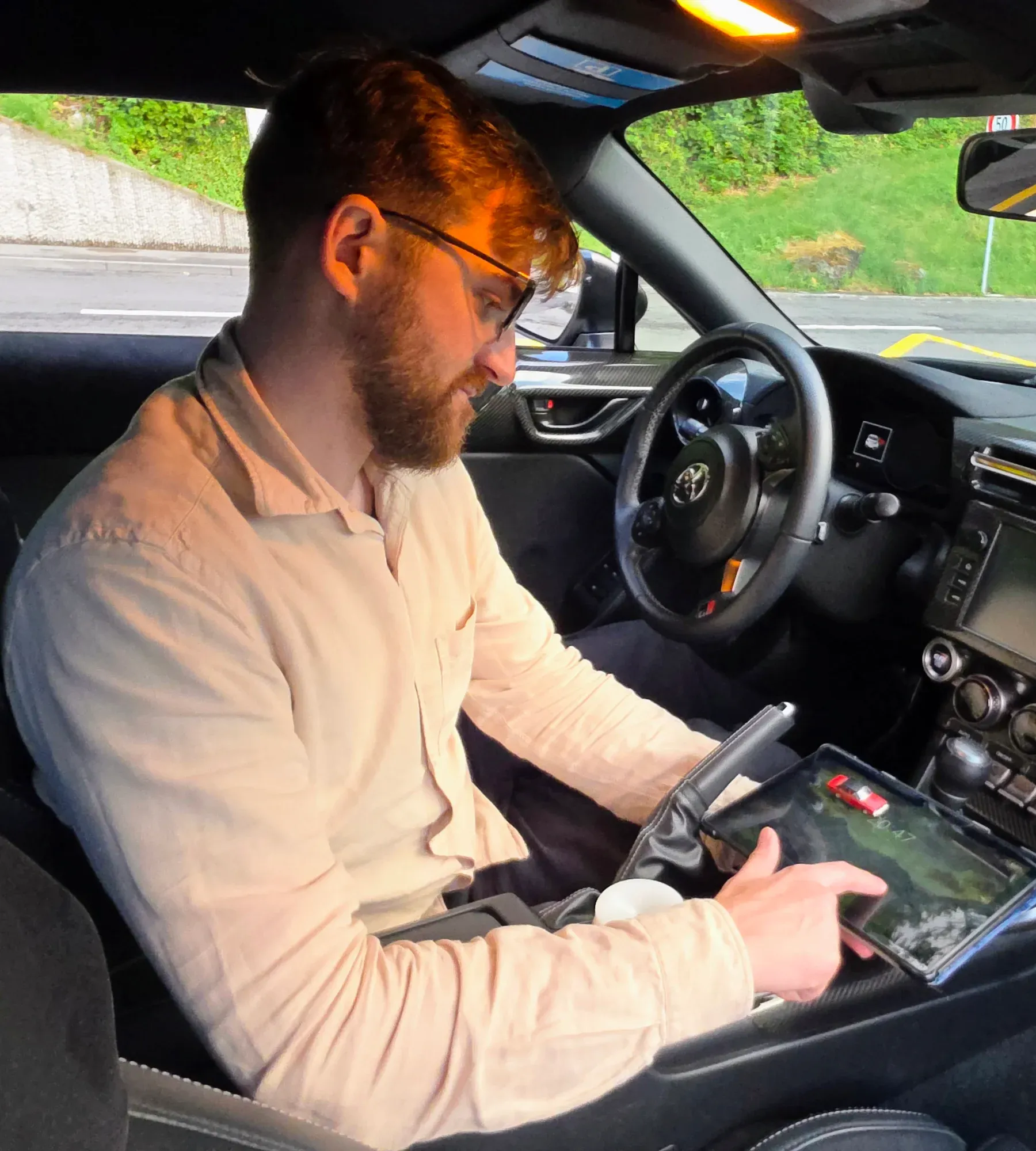 Fahrlehrer Patrik Stadelmann bereitet im Toyota GR86 die nächste Fahrstunde am Tablet vor