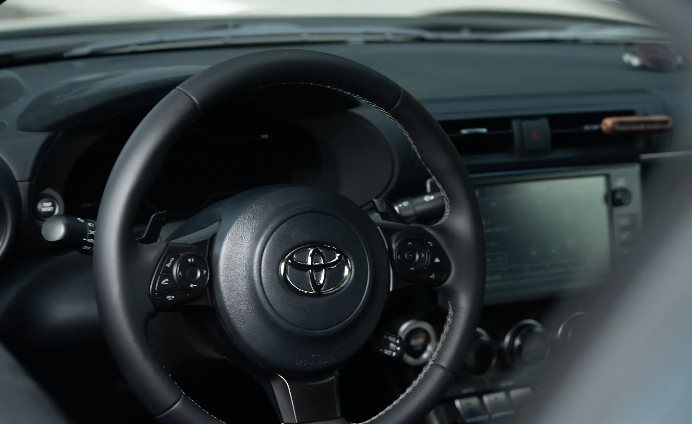 Steering wheel and dashboard of the Initial Drive Toyota GR86 in daylight – the car you take your test in