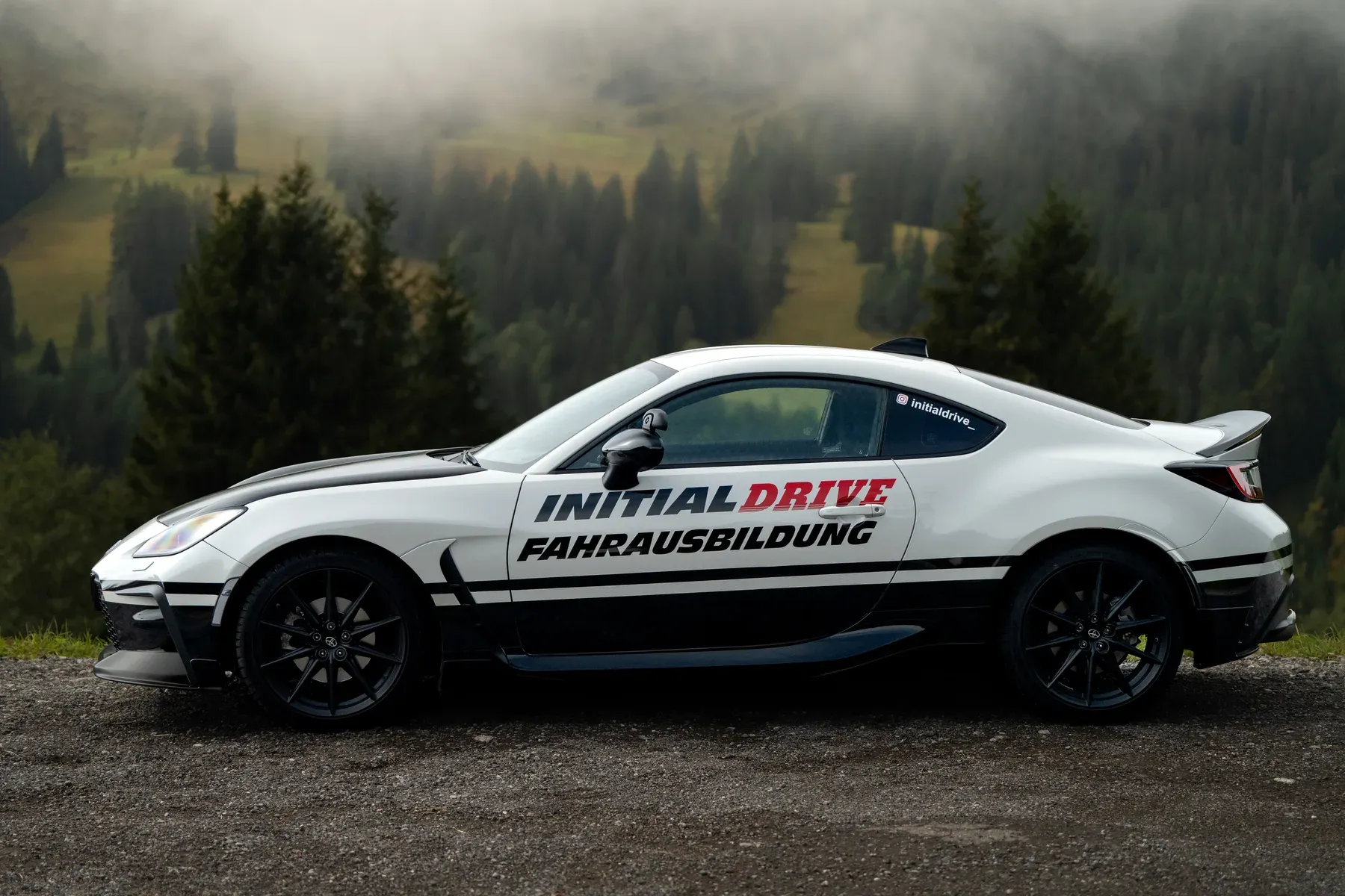 Toyota GR86 von Initial Drive in der Seitenansicht: flach und tief, vor nebligem Bergwald